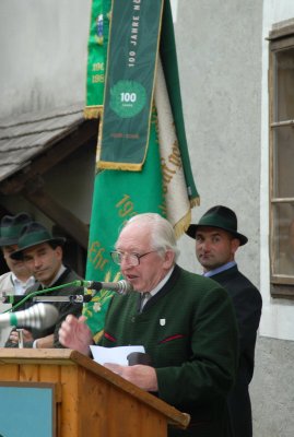 Heimatdichter Sepp Tiefenbacher vor der neu renovierten Fahne