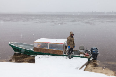 Taxi driver Robert Blueboy waits by his boat on the Moose River.