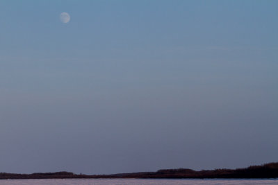 Pale moon in the Christmas Day sky over the Moose River at Moosonee