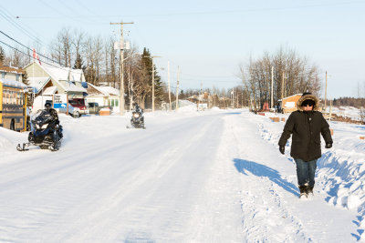 Two snowmobiles and a pedestrian on Revillon Road