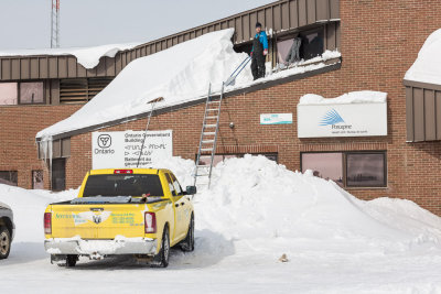Cleaning snow off roof of Ontario Government Building 2013 March 16th.