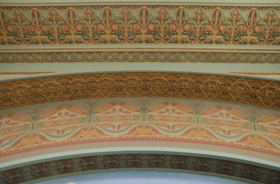 Terracotta and painted bands of ornament over central mural