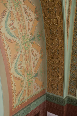 Painted and terracotta ornament on arch above central mural