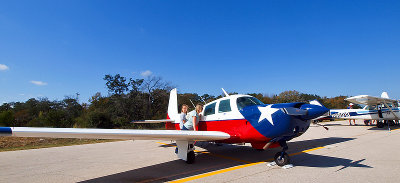 Two young women look over a plane sporting the colors of the US flag.