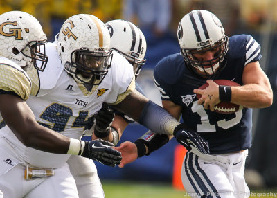 Jackets DE Izaan Cross gets help from teammates to bring down BYU QB Nelson