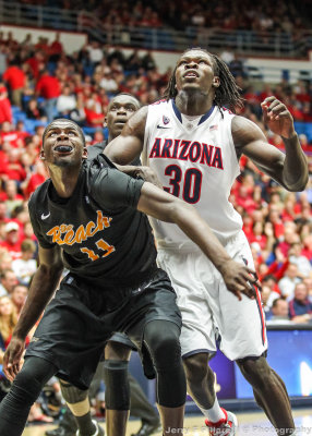 Cats F Angelo Chol fights for position under the basket with 49ers F Ennis