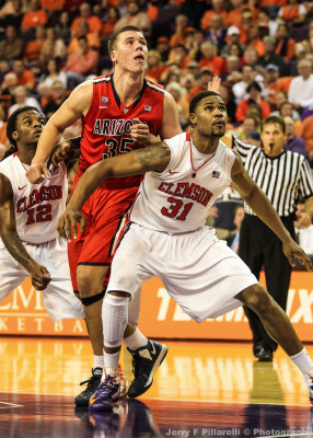 Arizona C Tarczewski jostles with Clemson G Rod Hall and F Booker for rebounding position