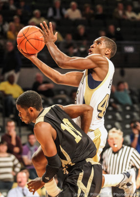 Yellow Jackets G Solomon Poole elevates to the basket over Hornets G Ryan Watts