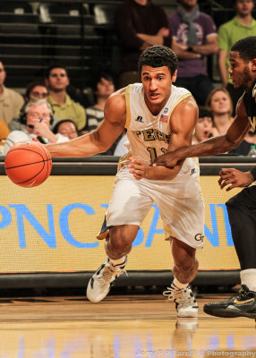 Yellow Jackets G Bolden drives around a Hornets defender