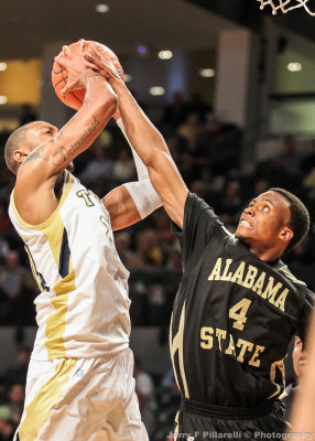 Yellow Jackets F Holsey has his shot contested by Hornets G Joshua Freelove