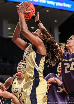 Yellow Jackets F Rogers puts up a shot after going by Huskies F Deborah Meeks