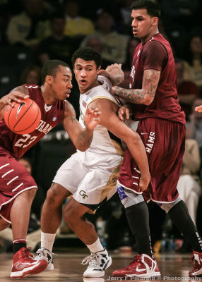 Jackets G Chris Bolden fights his way through a screen set by Rams F Gaston to stay with G Mandell Thomas