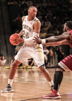 Yellow Jackets F Holsey looks past a Rams defender from the top of the three point line