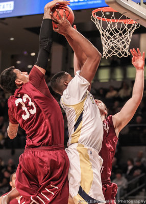 Yellow Jackets F Carter has his shot blocked from behind by Rams F Gaston