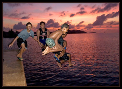 kids enjoying a sunset dip in the ocean