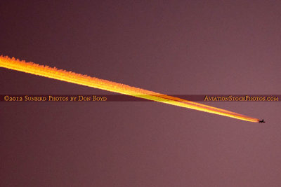 2012 - unknown four-engine airliner leaving a sunlit contrail across the sky sunset stock photo #2464
