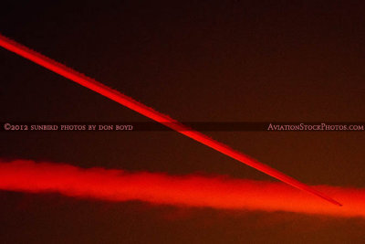 2012 - unknown four-engine airliner leaving a sunlit contrail as it flies in front of another contrail stock photo #2474