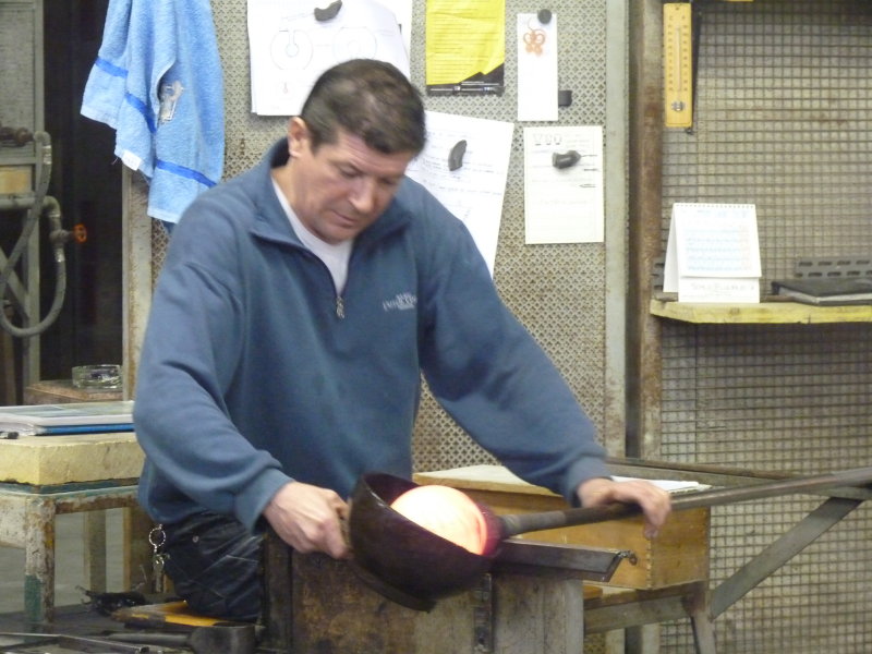 Glass artist at Linea Art Factory and Studio, rounding the glass