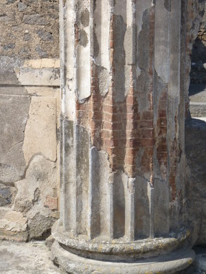 Column showing brick interior, plastered to look like marble