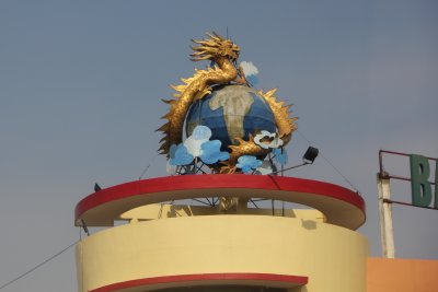 Dragon-wrapped globe on top of a building.