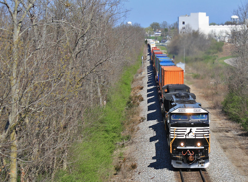 NS 223 has a spit-shined new SD60E leading as the train passes the Corning Glass plant at Harrodsburg 