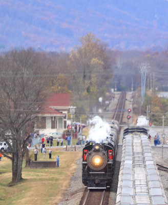 SR 630 passes the crowd at Spring City depot , as a Northbound grain train waits in the siding 