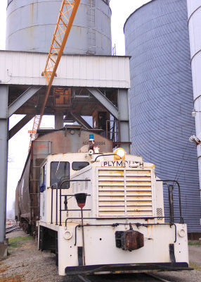 A Plymouth switcher loads a pair of covered hoppers at the Gibson City South elevator 