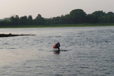 Man swimming across narrow stretch of lake