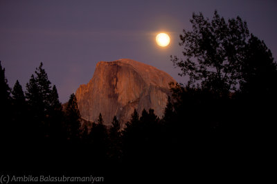 A full moon hangs over Half Dome