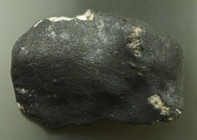 Chelyabinsk meteorite, 35 mm, 24 g, showing dark primary fusion crust. 15 February 2013.