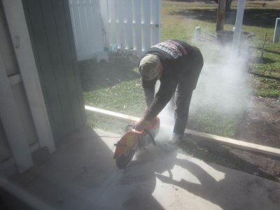 Cutting through the concrete of the back porch
