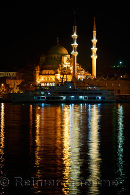 The New Mosque in early morning before sunrise with lights reflected in the Golden Horn Istanbul