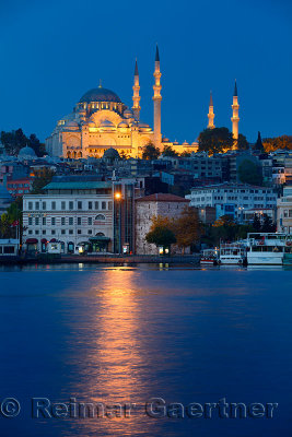 Lights of Suleymaniye Mosque Istanbul reflected at dawn on Golden Horn water