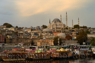 Rustem Pasha and Suleymaniye Mosques at sunrise with tour boats docked on the Golden Horn Istanbul