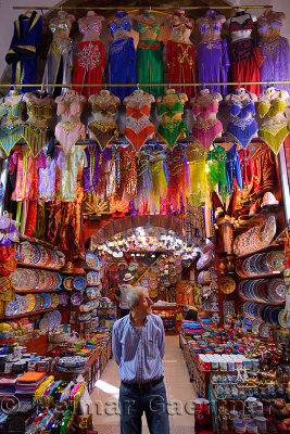 Shop worker in the Egyptian Spice Bazaar Istanbul with belly dancing costumes and ceramics