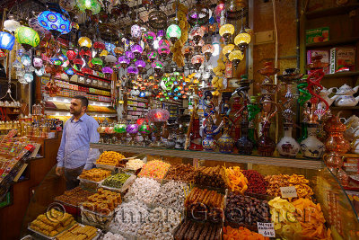 Shop worker in the Egyptian Spice Bazaar Istanbul with Turkish Delight water pipes and lamps