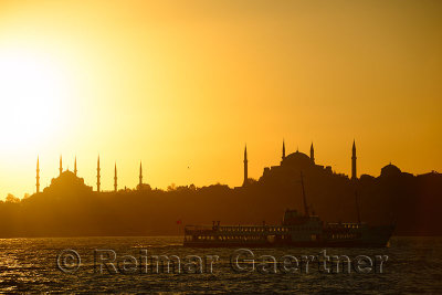 Blue Mosque and Hagia Sophia minarets silhouettes at sundown over the Bosphorus with sea bus Istanbul