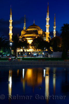 Lights on Blue Mosque at dusk with reflections in fountain Istanbul Turkey