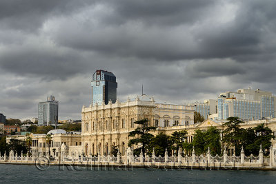 Facade of Dolmabahce Palace surrounded by modern buildings on the Bosphorus Strait Istanbul