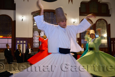 Male Sufi Whirling Dervish in a Sema Ceremony with musicians and women at Istanbul train station