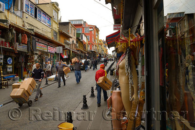 Coblestone street Uzun carsj Caddesi in Istanbul with shops and workers carrying boxes