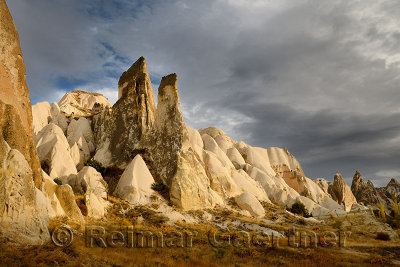 Evening sun on rock spires of the Red Valley with cave house Cappadocia Turkey