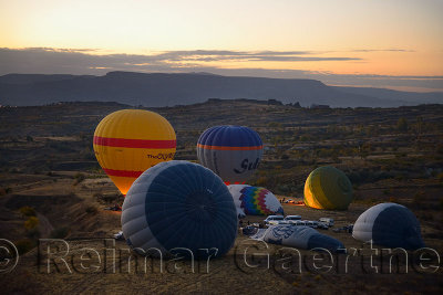 Hot air balloons being inflated and taking off at dawn in Cappadocia Turkey