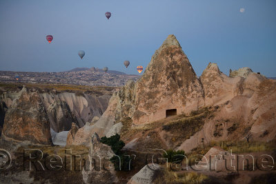 View of Uchisar city in Cappadocia Turkey before dawn with moon from a hot air balloon