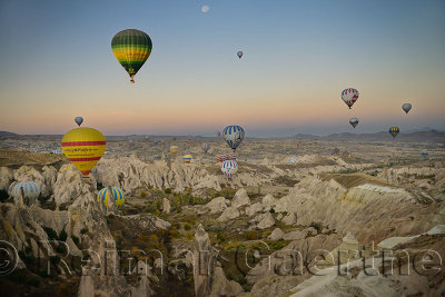 Hot air balloons over the Red Valley Cappadocia Turkey at dawn with moon