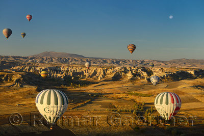 Goreme Love Valley Cappadocia Turkey in the morning with hot air balloons and moon