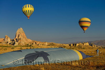 Operator folding a deflating hot air balloon on the ground in Cappadocia Turkey