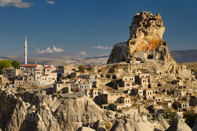 View of Ortasihar rock Castle with minaret Mount Erciyes and fairy chimneys Cappadocia Turkey