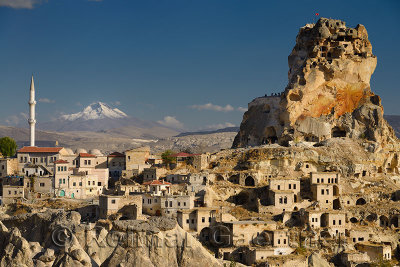 Ortasihar rock Castle with minaret Mount Erciyes and fairy chimneys Cappadocia Turkey