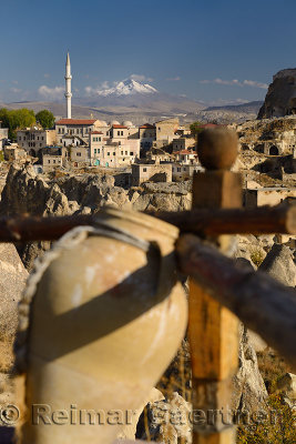 Houses and Mosque in Ortasihar with Mount Erciyes and fairy chimneys and clay pot Cappadocia Turkey